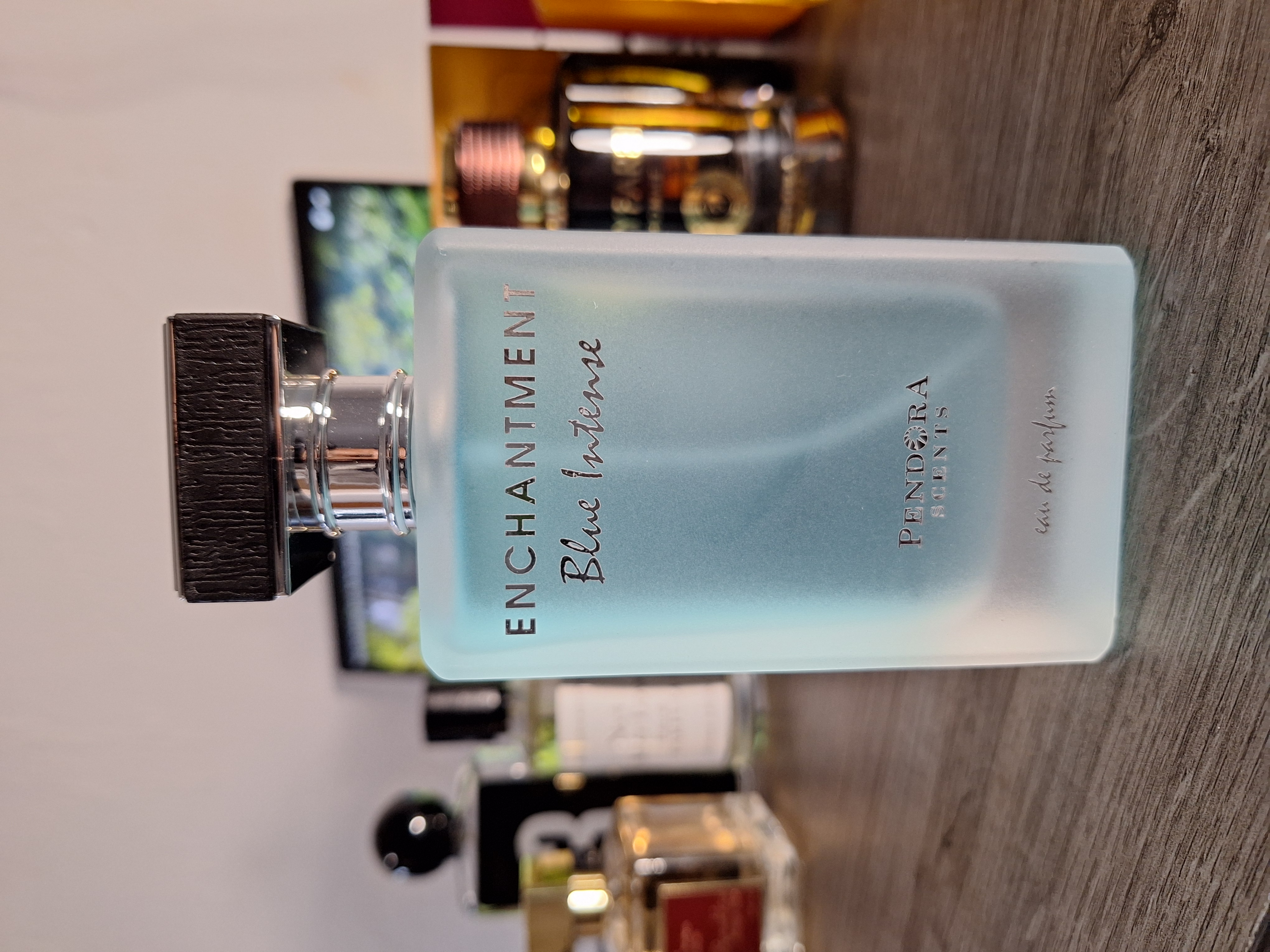 Enchantment perfume bottle with delicate floral design and pink liquid
